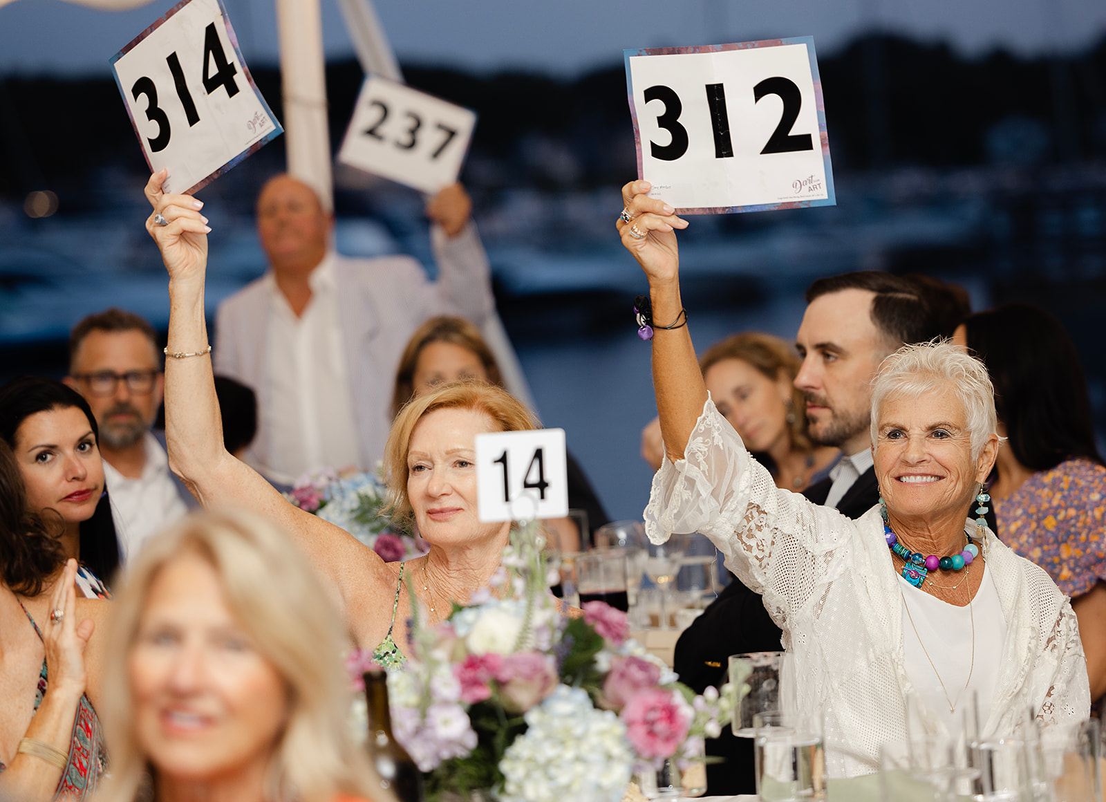 Guests placing bids to fund arts education and programming in Northern Michigan by supporting Crooked Tree Arts Center’s mission. Featuring Allisa Kugler (bidder 314 on left) and Jane Mueller (bidder 312 on right). 